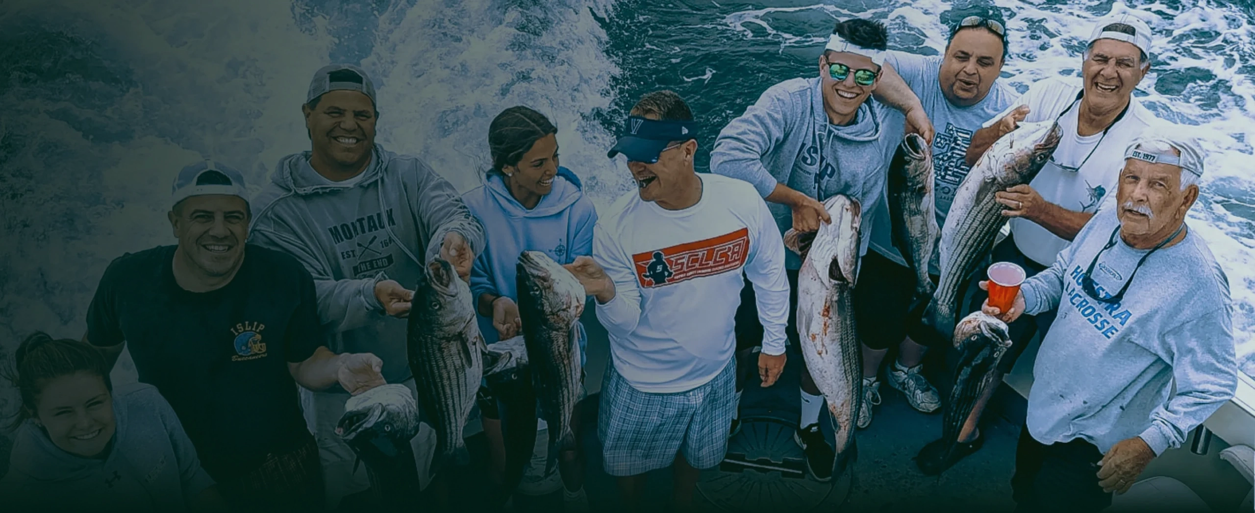 A group of people showing off the fish they just caught.